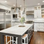 White and grey themed kitchen equipped with stainless steel appliances