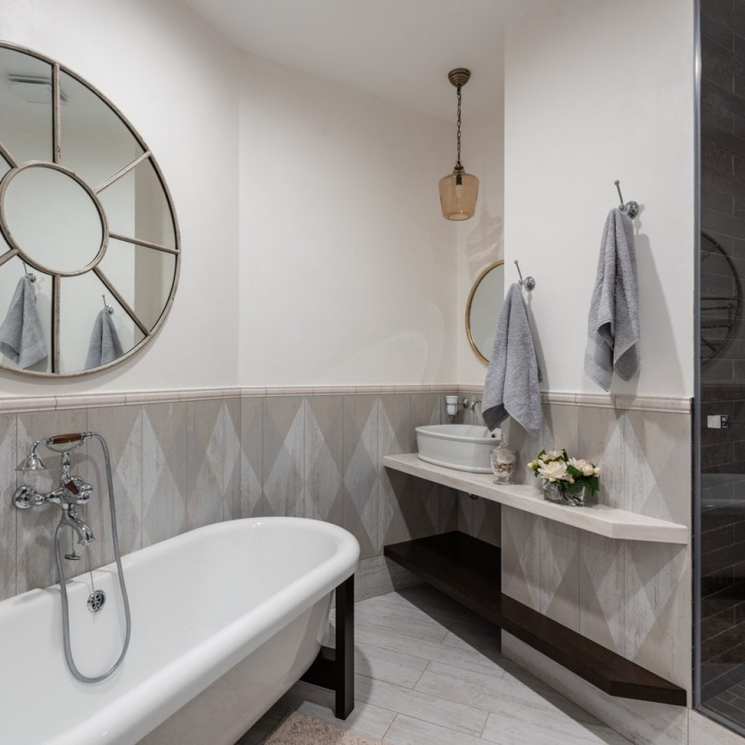 newly renovated and financed bathroom with circular mirror