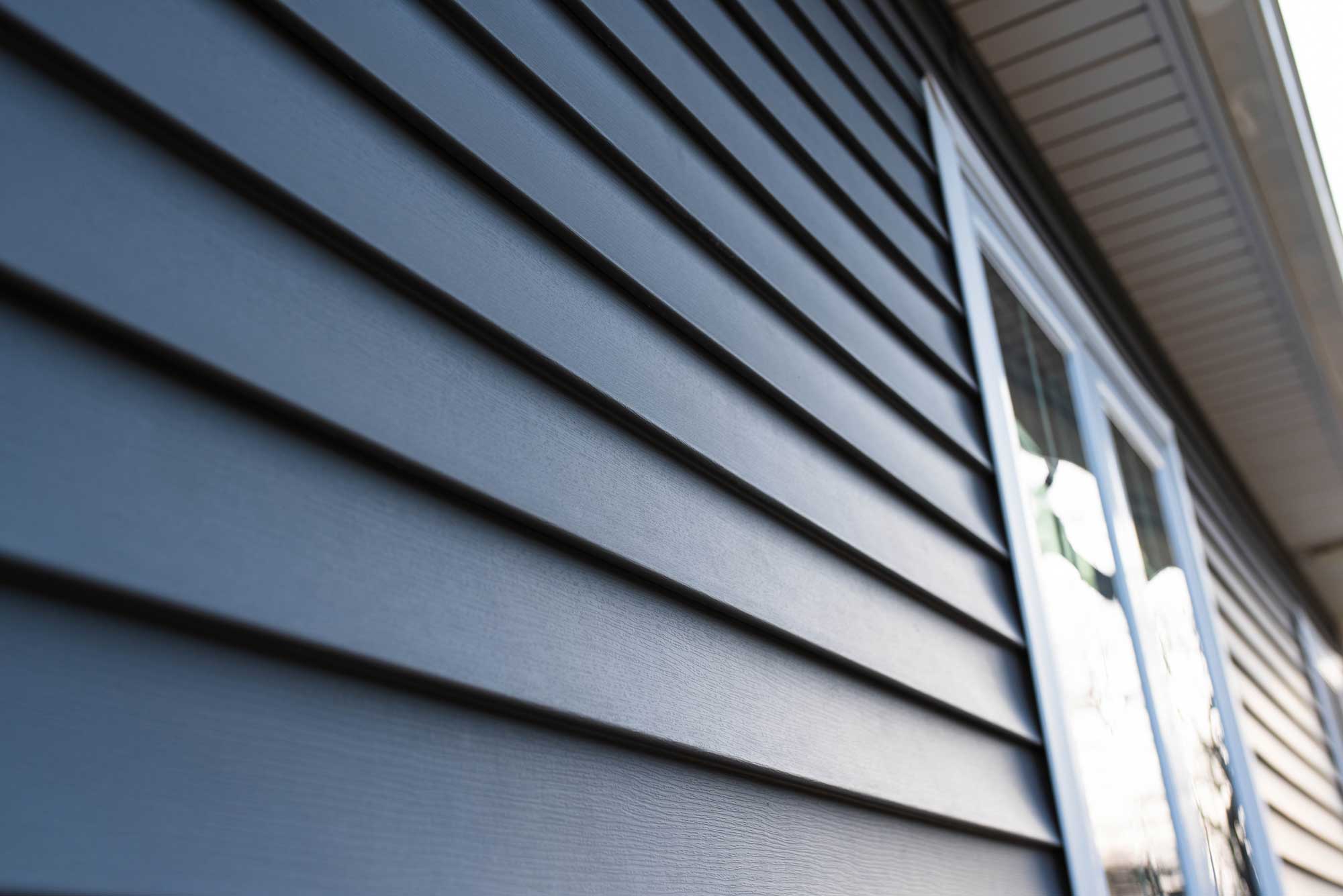 Closeup of blue lap siding on a home exterior